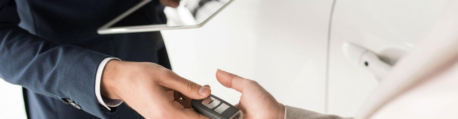 car dealer hands over vehicle keys to customer