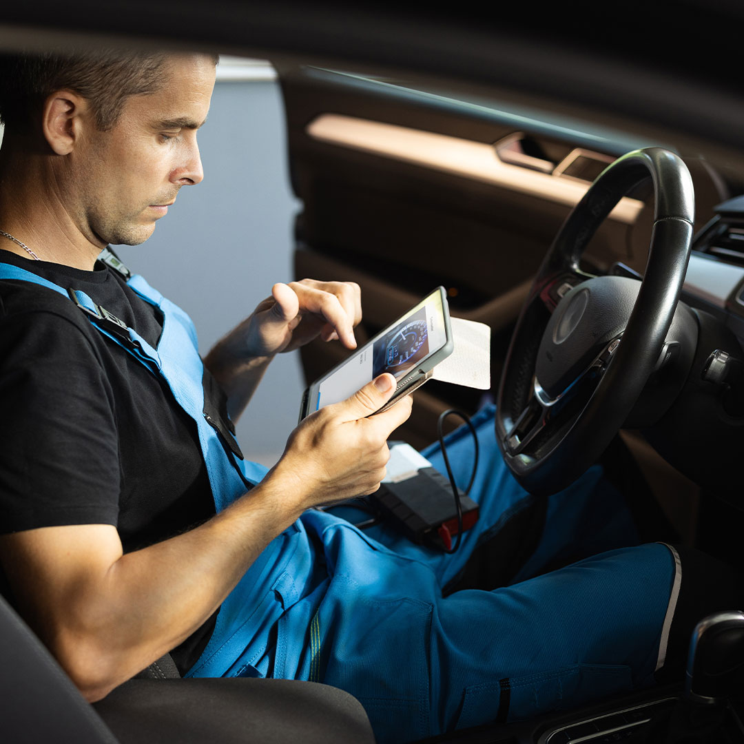 Technician checking the odometer just scanned with a tablet