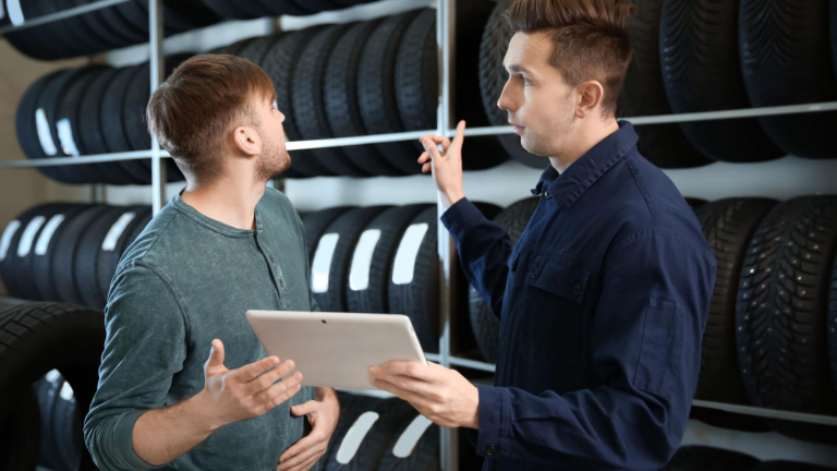 Technician with customer choosing tire for vehicle