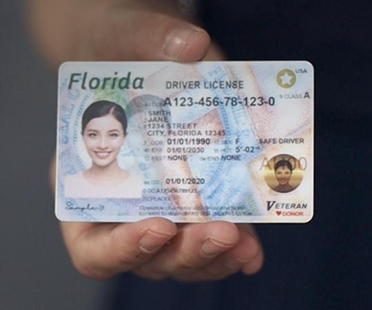 A hand holding a driver´s licence from Florida